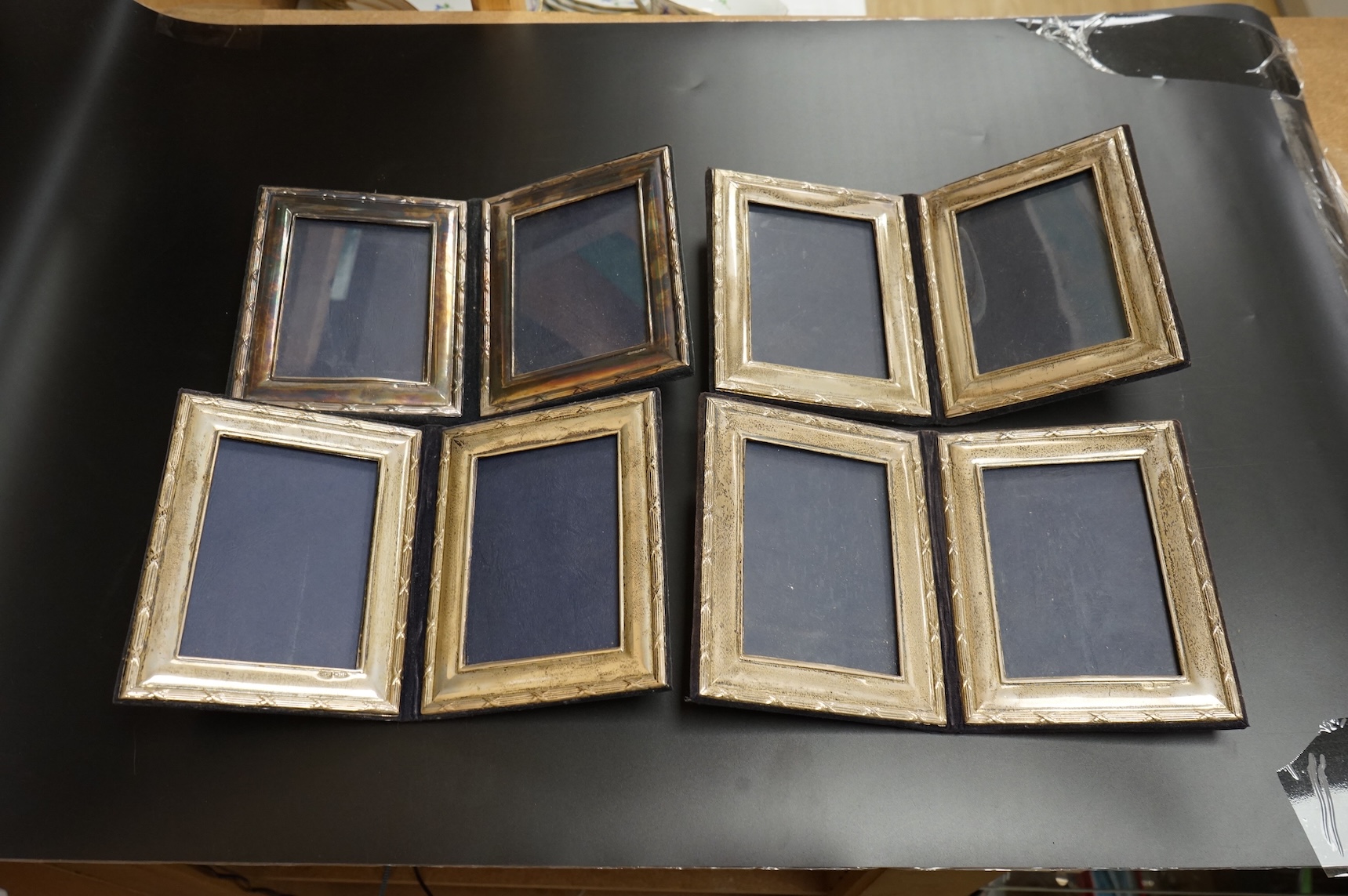 A late Victorian repousse silver mounted rectangular photograph frame, Birmingham, 1898, 17.9cm, a smaller Edwardian silver mounted photograph frame, Williams Ltd, Birmingham, 1905 and a set of four modern silver mounted